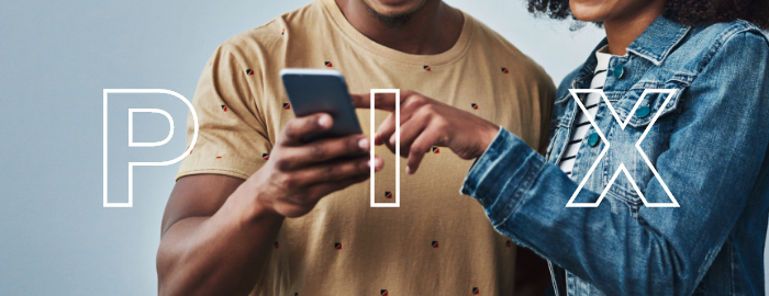 duas pessoas olhando para a tela de um celular, o que remete ao uso do PIX