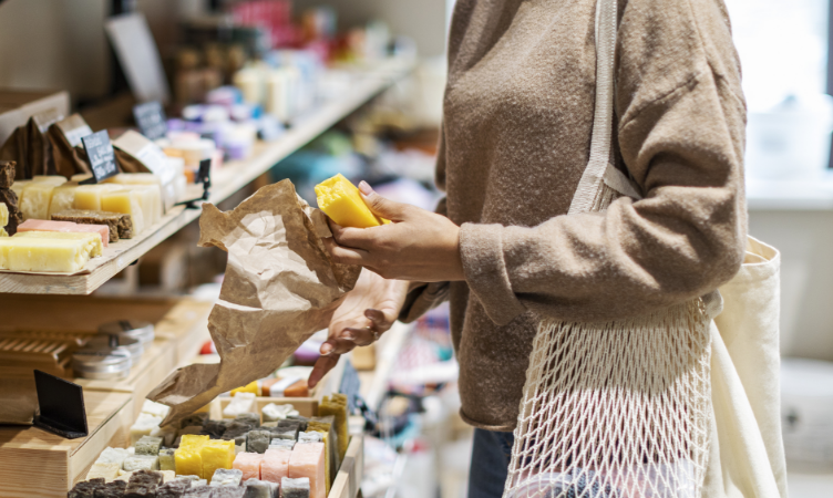 uma mulher segurando um cosmético barra em uma loja de produtos de beleza 