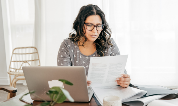 uma mulher em uma mesa de escritório analisando documentos