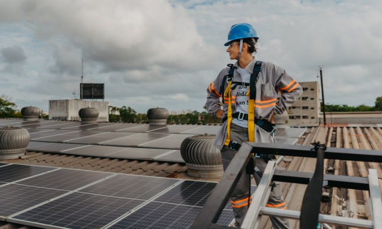 mercado livre de energia - mulher com equipamento de segurança perto de painéis de energia solar