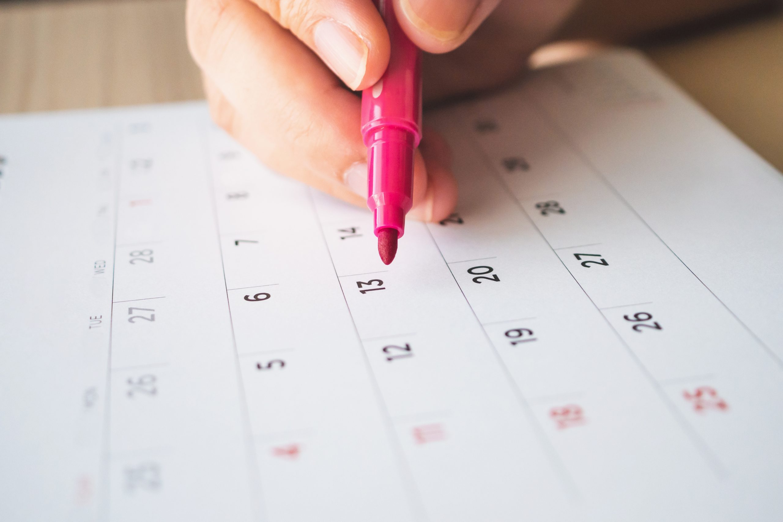 mão com caneta marcando datas no calendário de papel - MEI pode tirar férias 