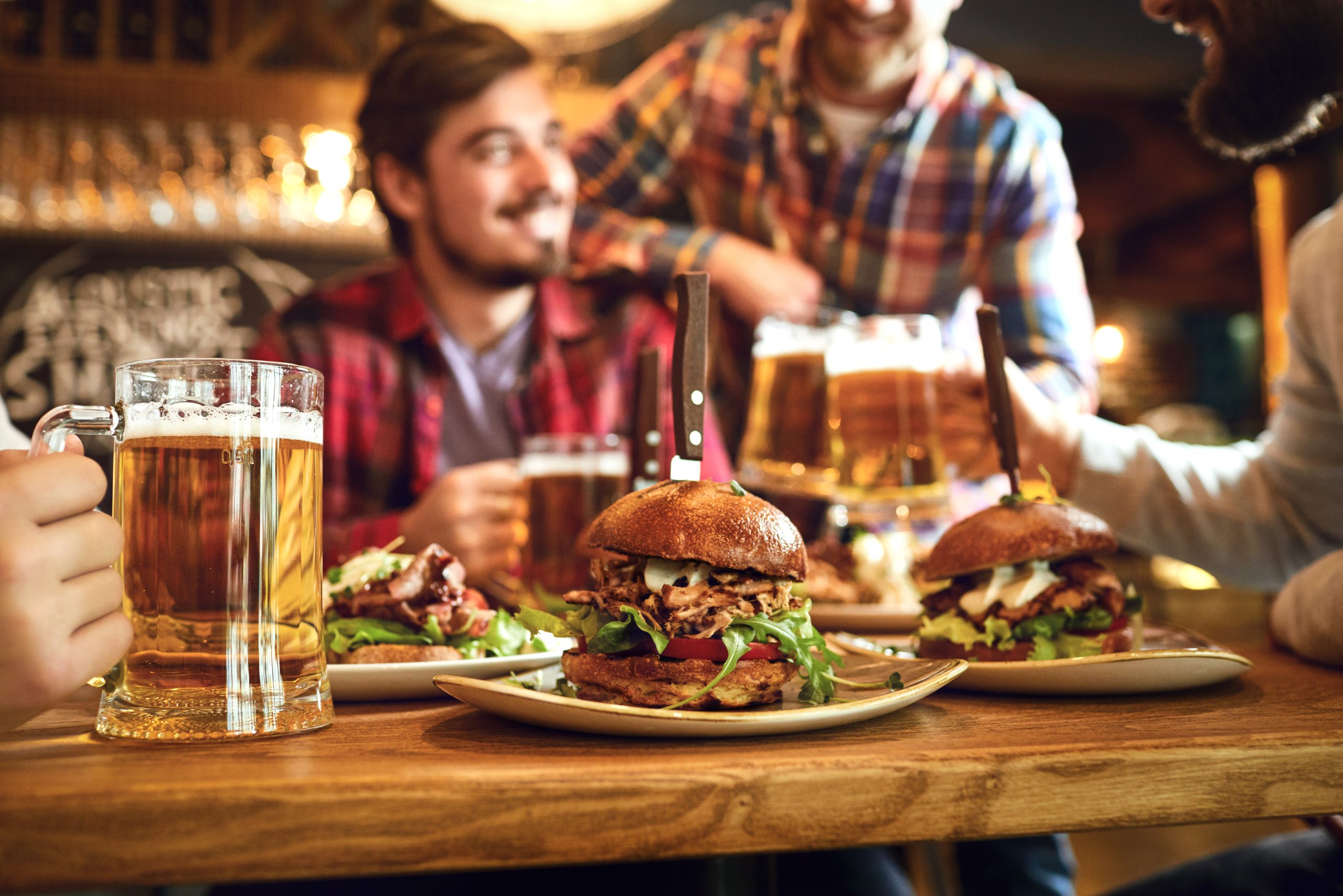 mercado de alimentos em 2023 - jovens brindando e comendo hambúrguer 