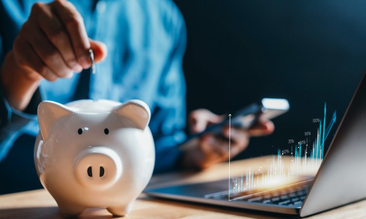 homem colocando moeda em cofre de porquinho - planejamento financeiro