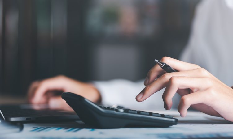 pessoa usando calculadora com caneta na mão - valor da empresa